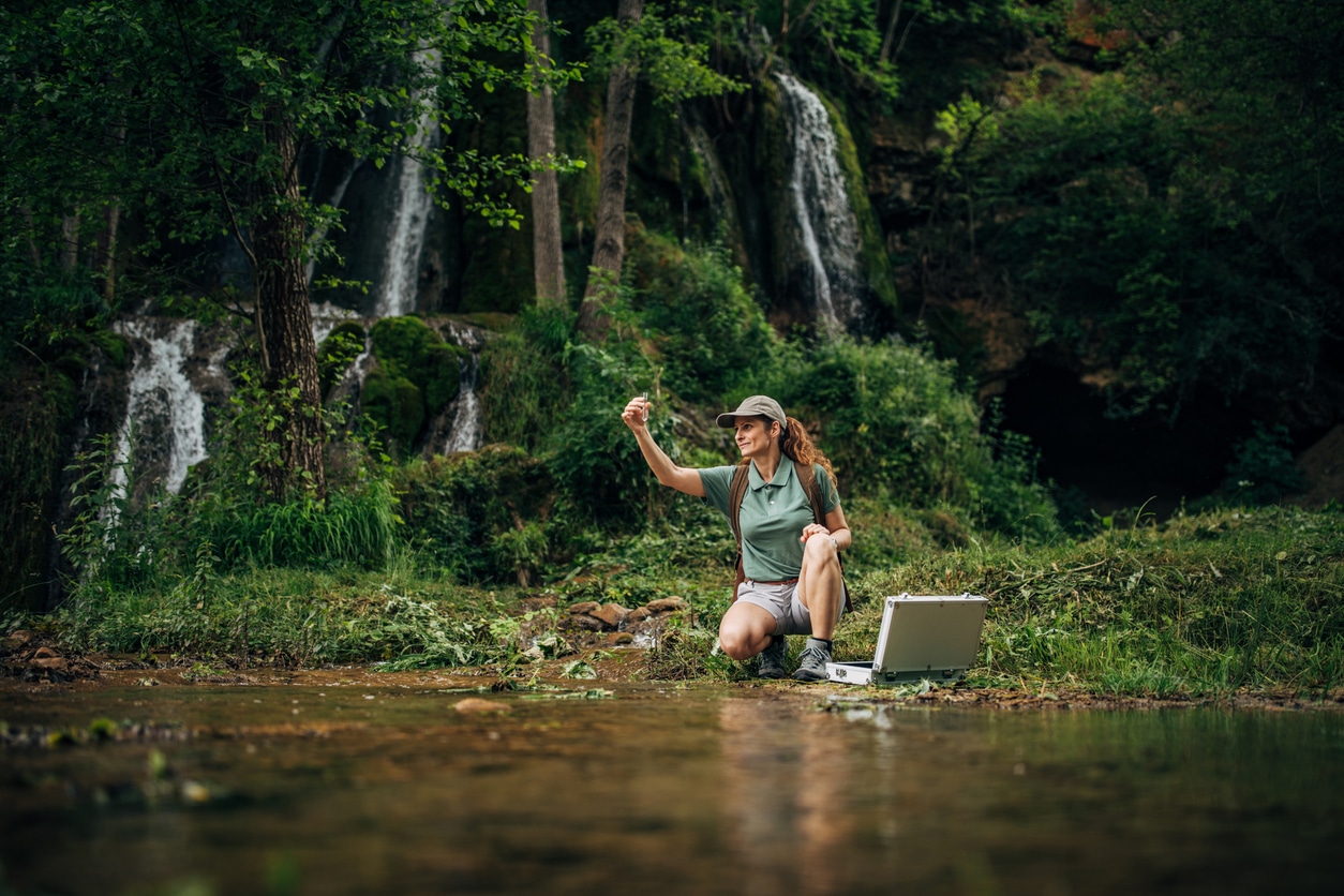 Image of a conservation researcher taking a biological water sample.